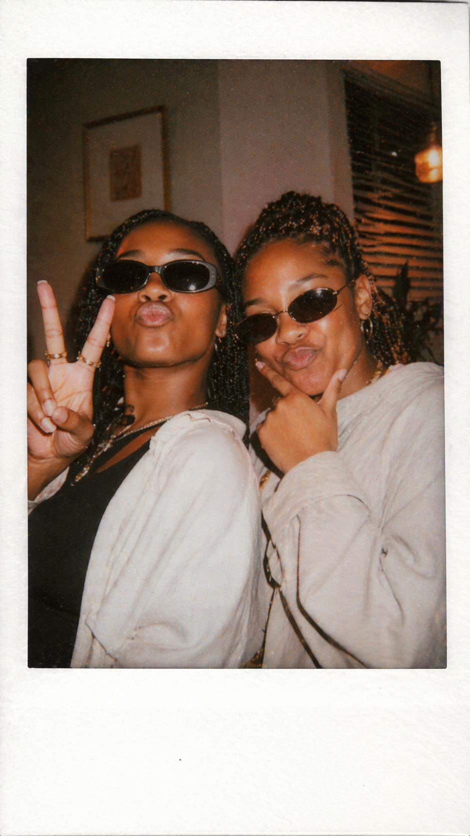 Polaroid of two friends throwing peace signs at a Lagos hangout